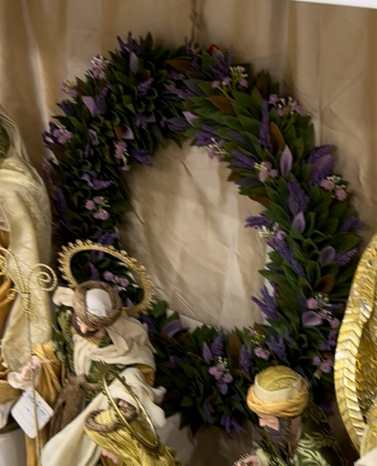 Decorative wreath with purple flowers and gold elements on a neutral background
