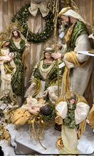 Decorative wreath with a figure in the center, surrounded by greenery and gold accents.